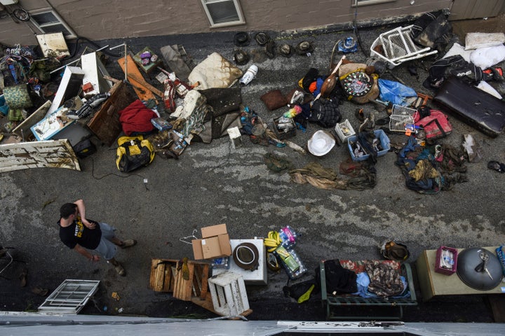 Chris Hasch wipes his brow as he helps family friends clear their basement after floods devastated the historic district of Ellicott City, Maryland, on July 31, 2016.