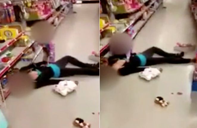 A little girl tries to wake her mother, who passed out in a Massachusetts store on Sunday.
