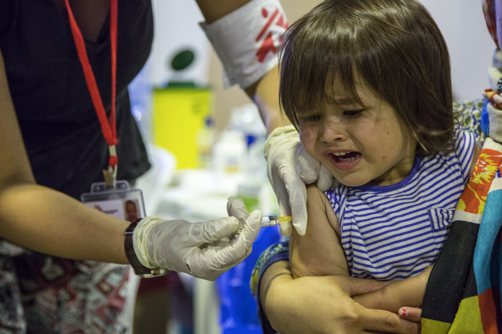 Doctors Without Borders gives a vaccine to a refugee child. 