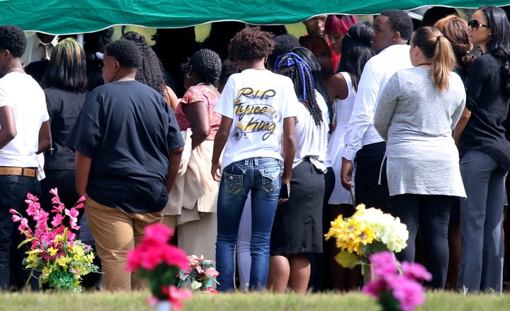 Mourners stand at the cemetery during the funeral of Tyre King.