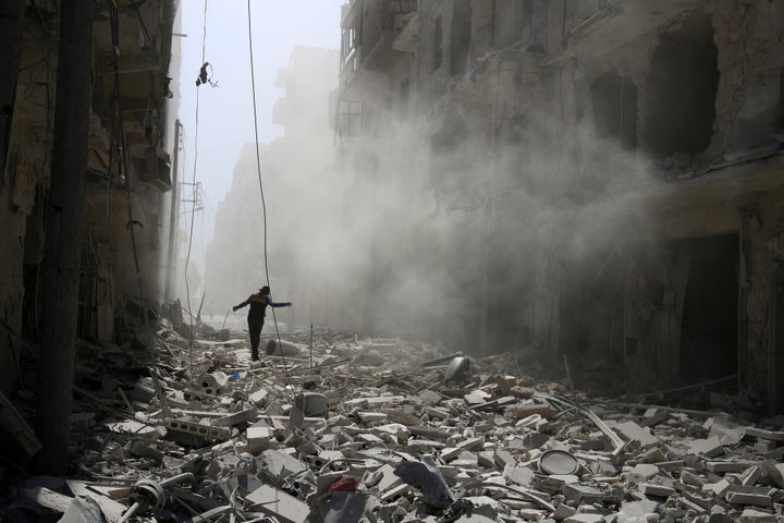 A man walks on the rubble of damaged buildings after an airstrike on the rebel held al-Qaterji neighbourhood of Aleppo, Syria