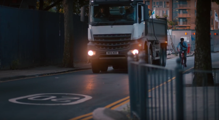 A cyclist is also shown next to a HGV