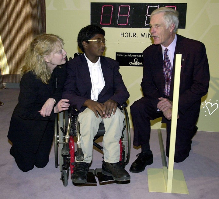 Mia Farrow and her adopted son Thaddeus speak with media mogul Ted Turner before a United Nations conference on the erad