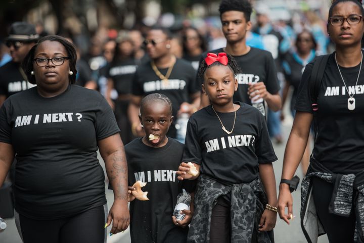Demonstrators walk down a street outside of Bank of America Stadium before an NFL football game between the Charlotte Panthers and the Minnesota Vikings on Sunday. 