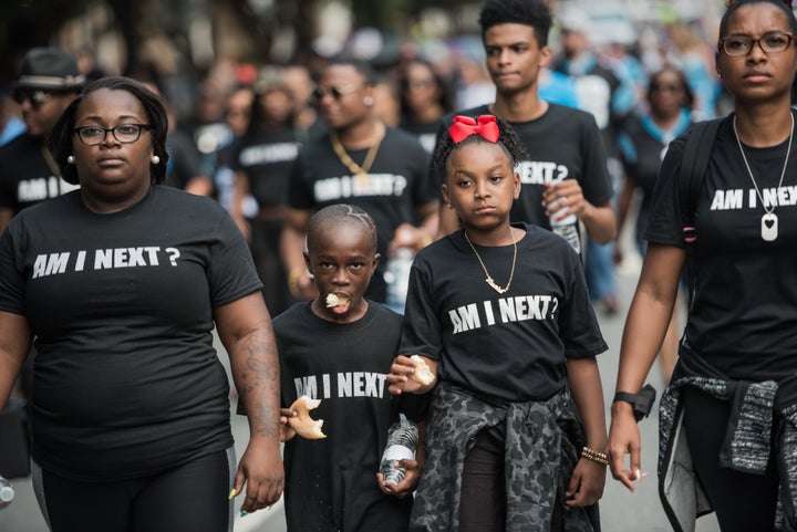Demonstrators walk down a street outside of Bank of America Stadium before an NFL football game between the Charlotte Panther