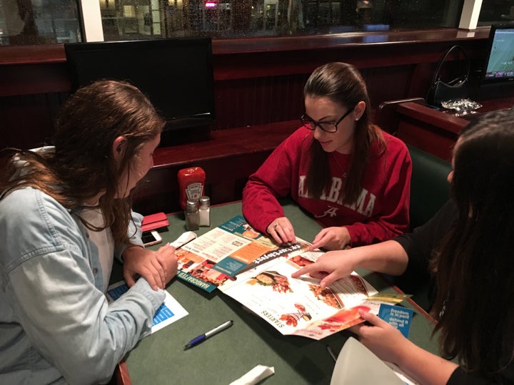 Hannah Lott (center) orders food with friends at a debate watch party. Lott, a conservative activist, is currently not planni