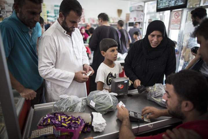 Refugees shop at a market with their bank card given by the Turkish Red Crescent in Turkey on September 24, 2015. 