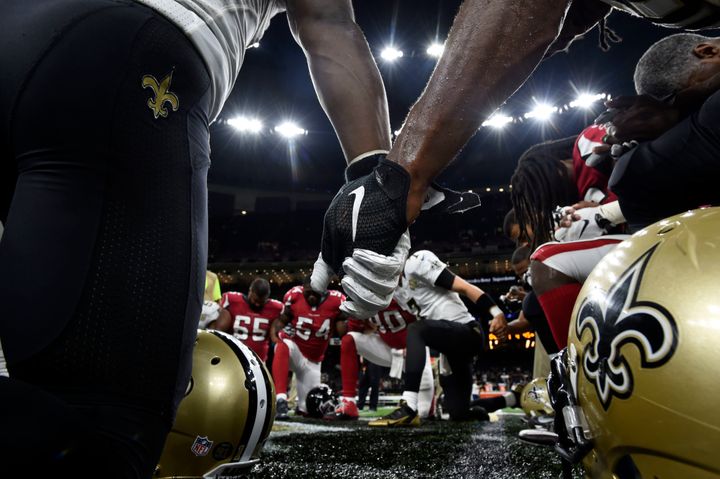 New Orleans Saints and Atlanta Falcons hold hands before an NFL football game in New Orleans on Sept. 26. The Falcons won 45-32.