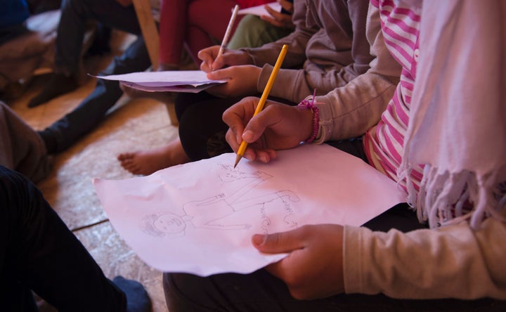 Parents associations in Greece are unhappy with the Ministry of Education for allowing refugee children to attend public schools. Above, children draw during an English lesson inside a tent at a makeshift camp at the Greek-Macedonian border near the village of Idomeni in May.