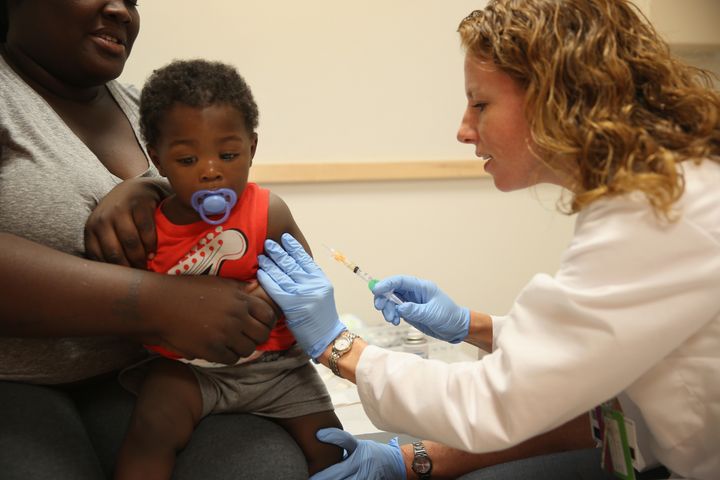 India Ampah holds her son, Keon Lockhart, 12 months old, as pediatrician Amanda Porro M.D. administers a measles vaccination during a visit to the Miami Children's Hospital on June 02, 2014 in Miami, Florida.