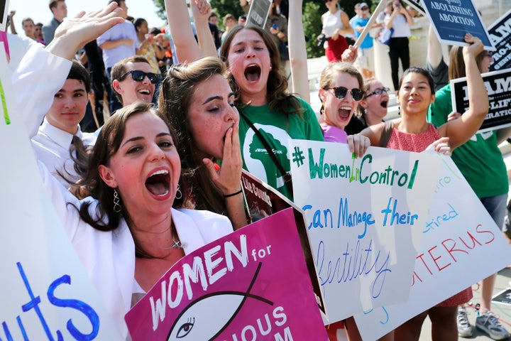 Anti-abortion demonstrators cheer as the ruling for Hobby Lobby was announced outside the U.S. Supreme Court in Washington Ju