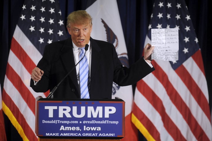 Republican presidential nominee Donald Trump holds up a sheet with poll numbers as he speaks at a rally in Ames, Iowa, on Jan. 19, 2016.