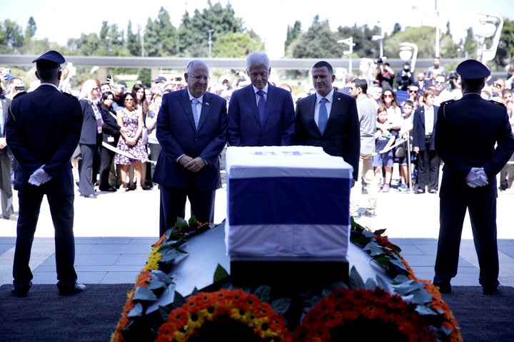 Former US President Bill Clinton (C), Israeli President Reuven Rivlin (L) and Knesset chairman Yuli Edelstein (R) stand in front of Peres' coffin.