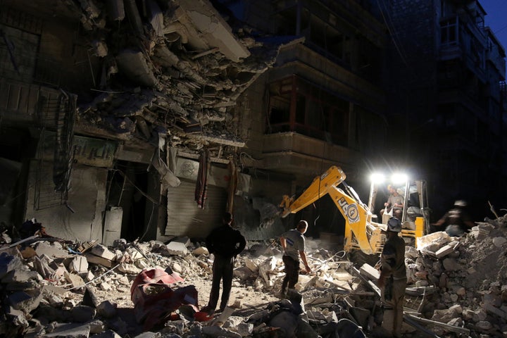 Civil Defense members search for survivors at a site hit by an airstrike in the rebel-held al-Shaar neighbourhood of Aleppo,