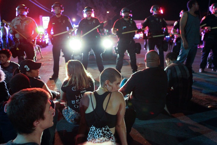 Protesters sit in front of a police line in El Cajon, a suburb of San Diego, California on September 28, 2016.