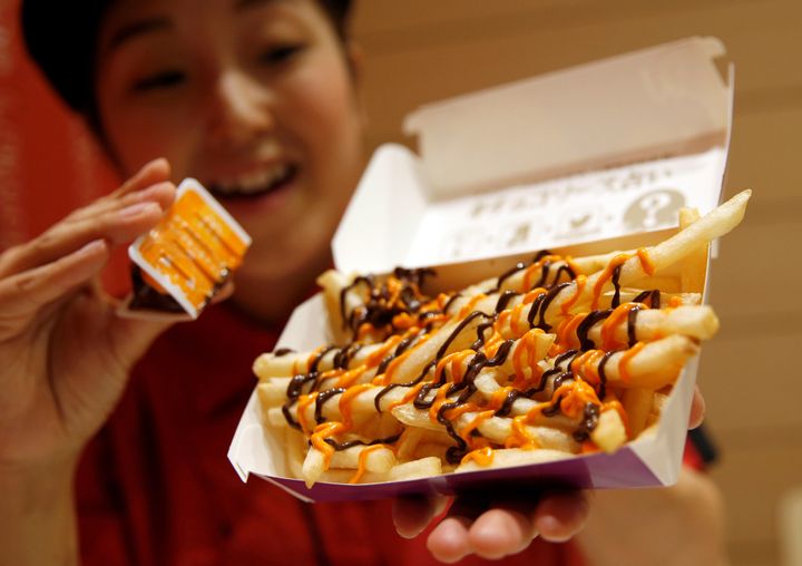 An employee of McDonald's Japan poses with the company's newest dish, "Choco-Pumpkin Fries."