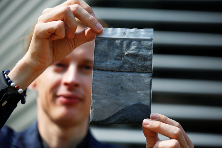 Dutch artist Daan Roosegaarde holds air pollution particles collected by the Smog Free Tower, as he presents his Smog Free Project in Beijing on Thursday.