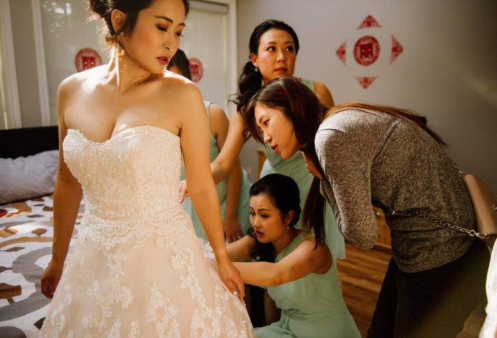 Jo Du and the women in her wedding party work to try to fix Du's wedding gown.