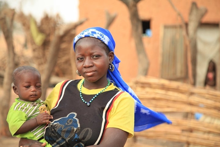 14-year old Nigerian girl holding her 7-month old baby.