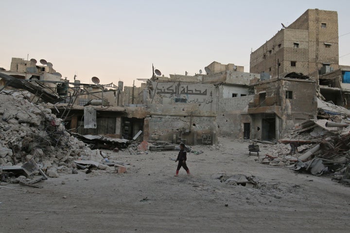 A boy walks amid damaged buildings in the rebel held area of al-Kalaseh neighbourhood of Aleppo, Syria, on Thursday.