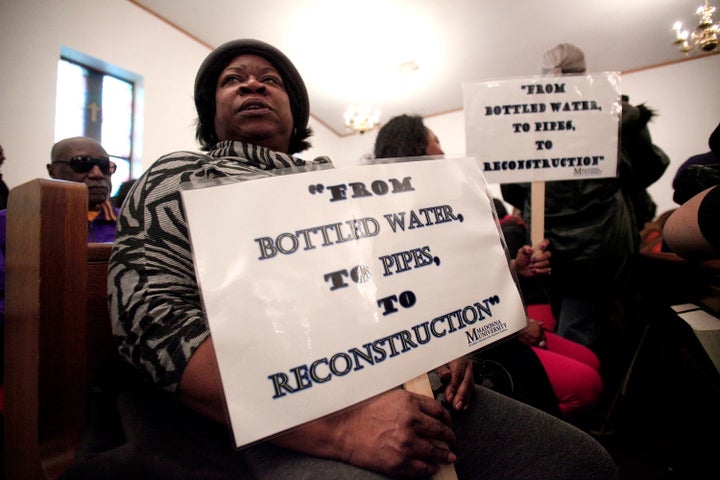 A woman holds a sign during a prayer service before a rally for clean water in Flint, Michigan, in February. Flint water
