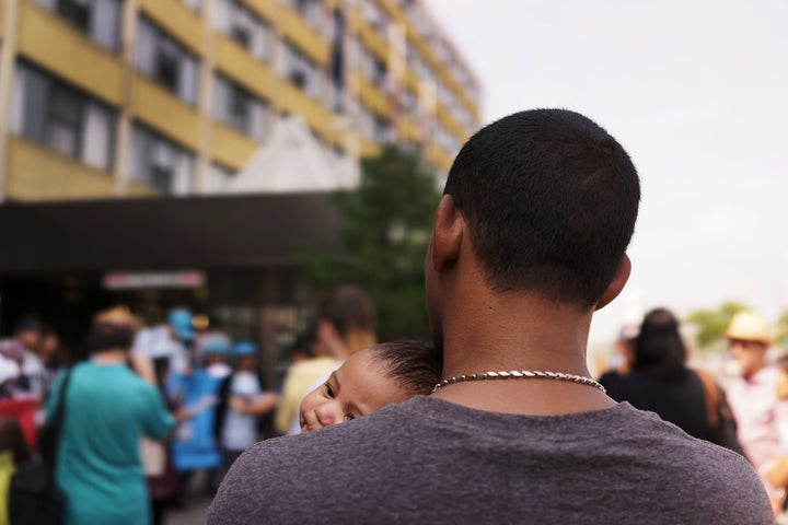 A man and child, who are both homeless, participate in a rally in support of residents at the controversial Pan Am Shelter in Queens, New York, on Aug. 20, 2014.