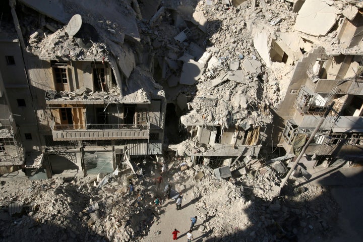 People dig in the rubble in an ongoing search for survivors at a site hit previously by an airstrike in the rebel-held Tariq