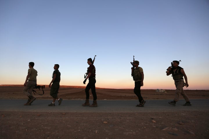 Rebel fighters carry their weapons in northern Aleppo countryside, Syria September 30, 2016.