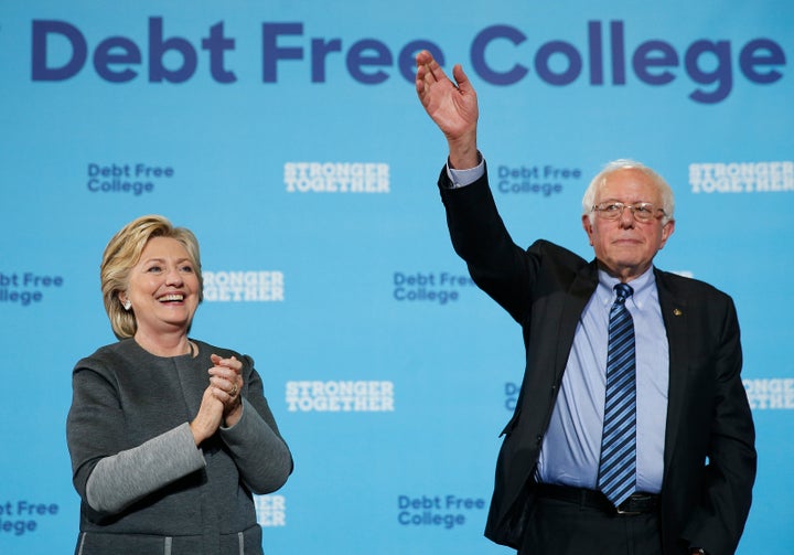 Hillary Clinton, left, and Bernie Sanders wave to the crowd at the conclusion of a campaign event at the University of New Ha