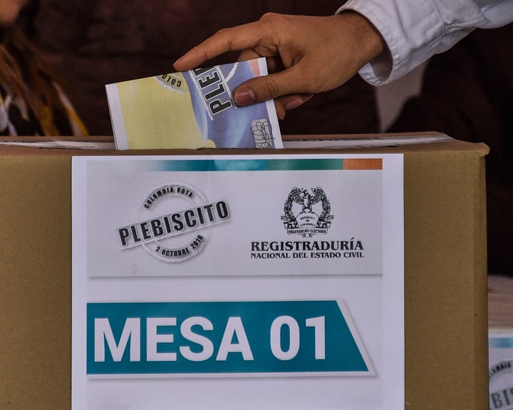 A Colombian citizen casts his vote during a referendum on whether to ratify a historic peace accord to end a 52-year war.