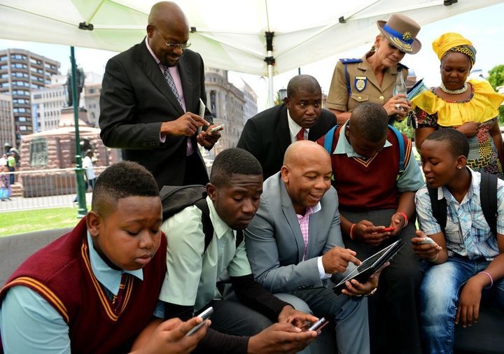 July 2016: Tshwane , South Africa Former Executive Mayor Kgosientso Ramokgopa, surrounded by school pupils and officials, samples the metropole’s free internet service