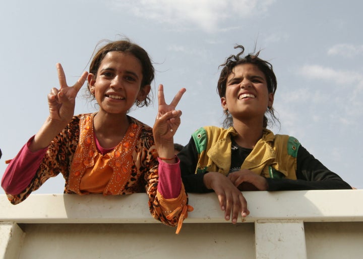 Displaced Iraqi girls from the northern Iraqi town of Qayyarah sit in a vehicle belonging to Iraqi security forces as they transfer to Tikrit on Aug. 29.