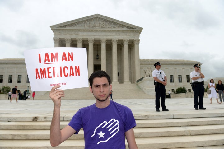 Immigration activist Julian Gomez of Define American holds a placard during an immigration rally outside the Supreme Court in Washington D.C., on June 23, 2016.