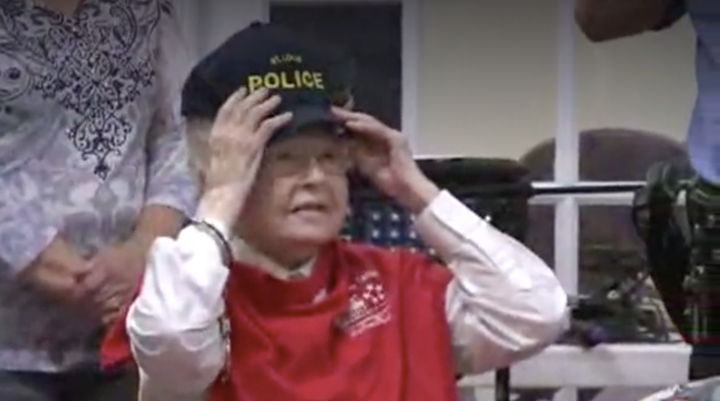 The do-gooder is seen trying on a St Louis Police Department hat after handing out handmade gifts to some of the senior center's guests.