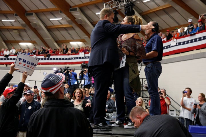 A protester is escorted out after she disrupted a rally with Republican presidential nominee Donald Trump and his supporters in Waukesha, Wisconsin.