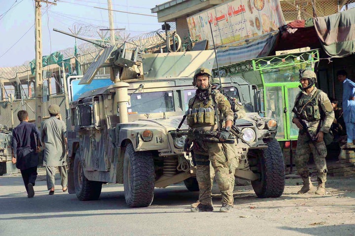 Afghan security forces keep watch in front of their armored vehicle in Kunduz city, Afghanistan on October 4, 2016.