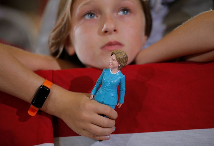 Nine-year-old Belle Shefrin holds a doll of U.S. Democratic presidential nominee Hillary Clinton while listening to Clinton speak at a campaign rally in Akron, Ohio, U.S., October 3, 2016.