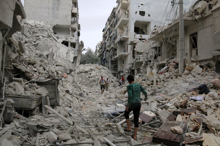 People walk through rubble caused by airstrikes in Aleppo's rebel-held Tariq al-Bab neighborhood on Sept. 23, 2016.