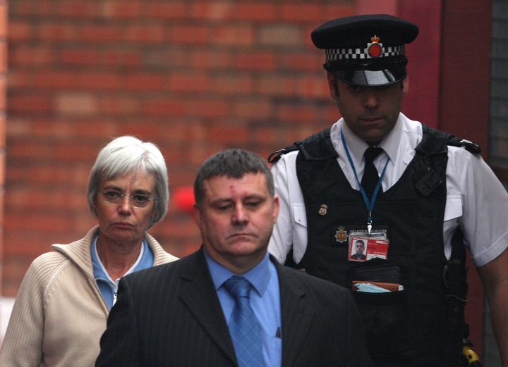 Anne Darwin is escorted by a police officer as she leaves Manchester Airport police station, northern England, December 9, 2007.