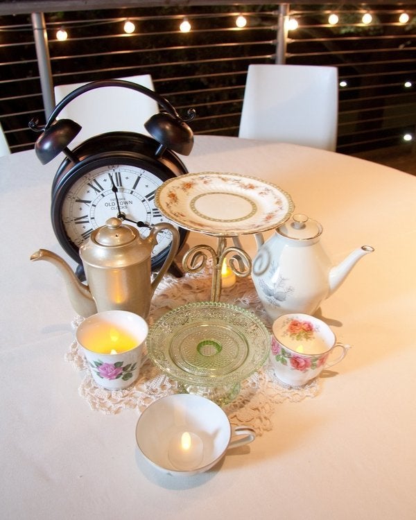 "Alice in Wonderland" table with teacups and a clock. 