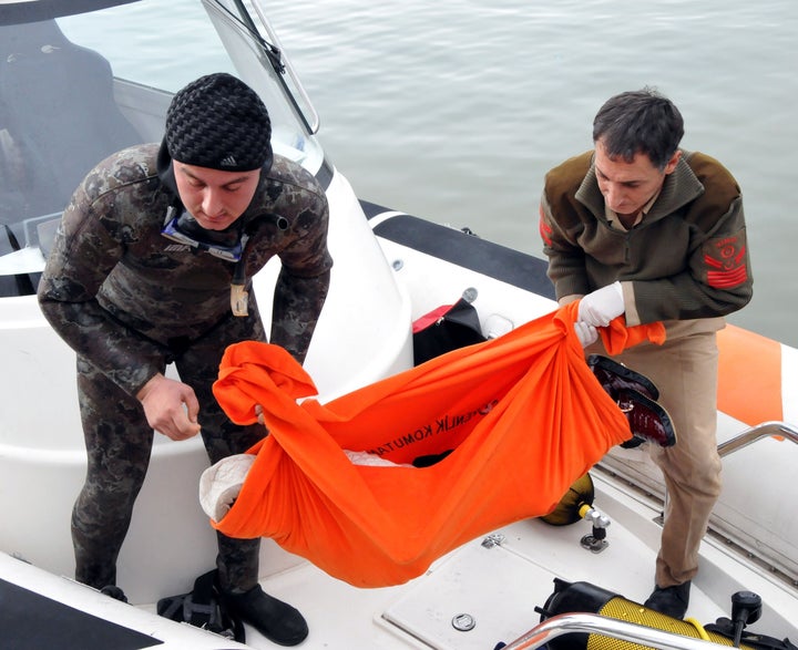 Turkish Coast Guard members carry the body of a refugee after a boat, which was carrying refugees, sank in the Aegean Sea on Jan. 11.