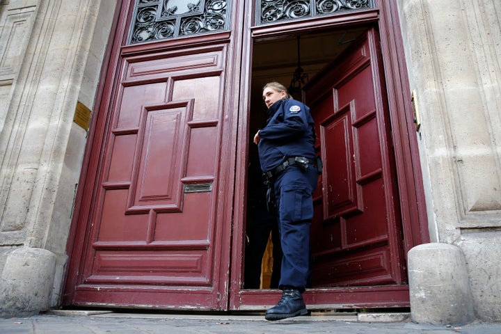 A police officer stands guard at the entrance of the luxury residence where masked men robbed Kardashian West