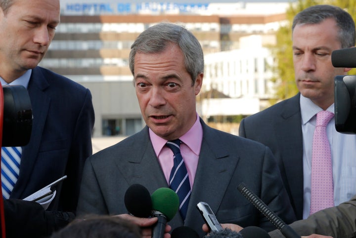 <strong>Farage (centre) speaks to journalists outside the Strasbourg hospital where Woolfe is being treated</strong>
