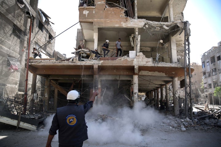 The White Helmets work around destroyed buildings following reported airstrikes on the rebel-held town of Douma, on the eastern outskirts of the capital Damascus, on Wednesday.