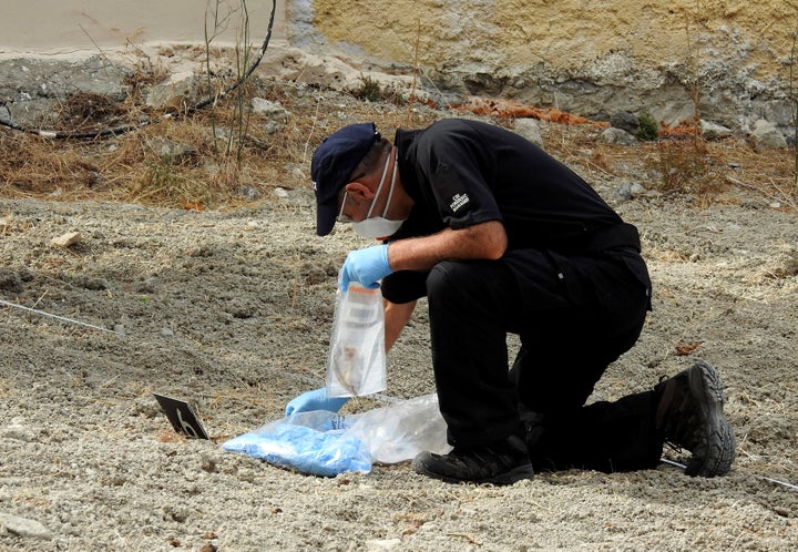 A police officer collects potential clues during the search for Ben Needham 