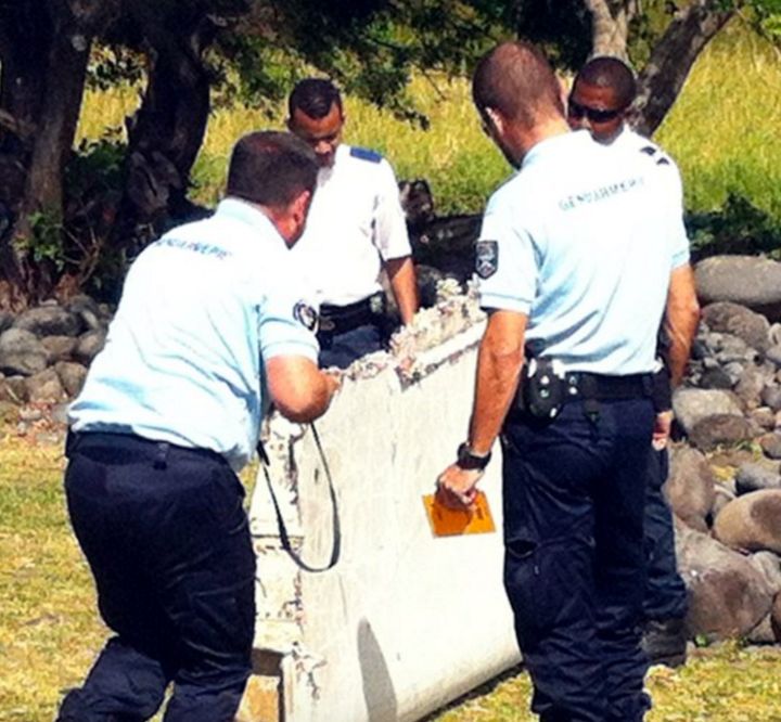 <strong>Officials carry the flaperon which washed up on Reunion Island last year</strong>