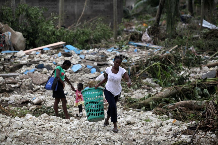 A woman carries a laundry basket in an area devastated by Hurricane Matthew in Cavaillon, Haiti, Oct. 6, 2016.