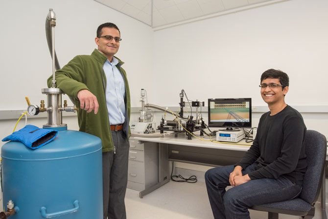 Berkeley Lab faculty scientist and UC Berkeley professor Ali Javey (left) and graduate student Sujay Desai created the smallest transistor to date. Next to them is a vacuum probe station used to measure the electrical characteristics of the 1-nanometer-long transistors 