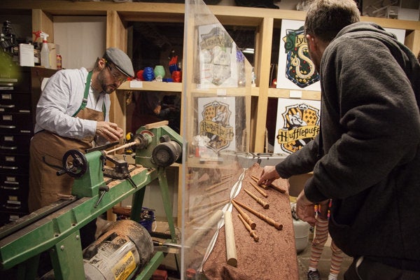 House crests sit on display behind a case of handcrafted wands. 