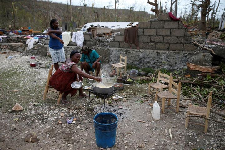 Women cook their meal in a partially destroyed school used as a shelter in Jeremie